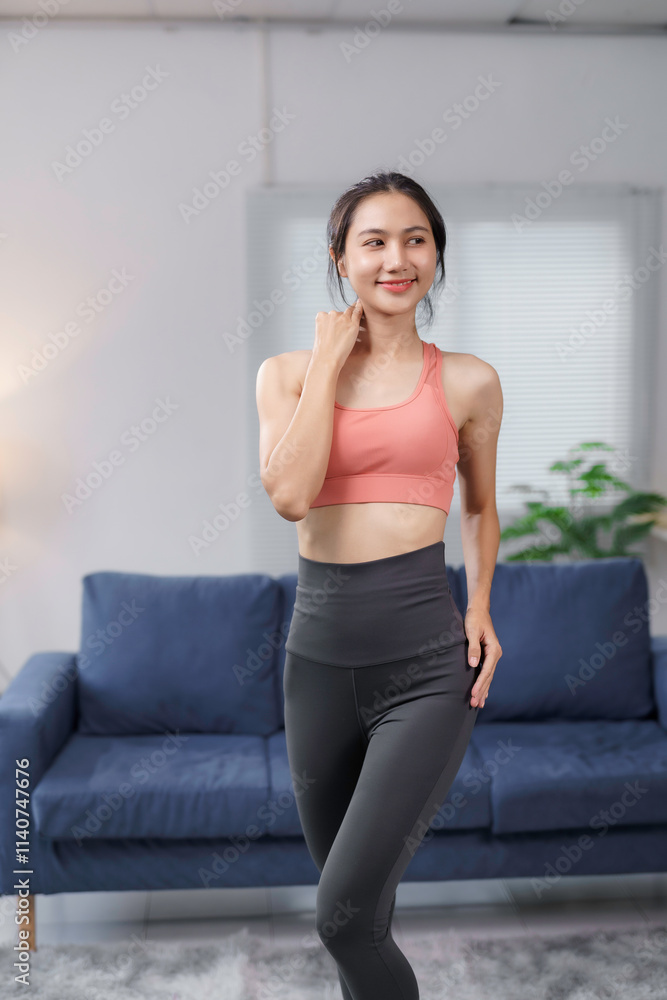 Fit asian woman wearing sportswear, posing confidently in her living room, promoting a healthy and active lifestyle Fit asian woman wearing sportswear, posing confidently in her living room, promoting a healthy and active lifestyle