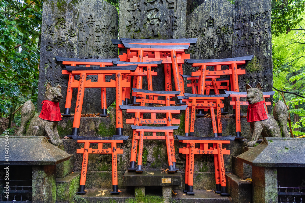 Small shinto place of worship with Torii Gates and inscriptioned stones at Fushimi Inari Taisha temple in Kyoto, Japan. ( Japanese inscriptions translated are different religion blessings) Small shinto place of worship with Torii Gates and inscriptioned stones at Fushimi Inari Taisha temple in Kyoto, Japan. ( Japanese inscriptions translated are different religion blessings)