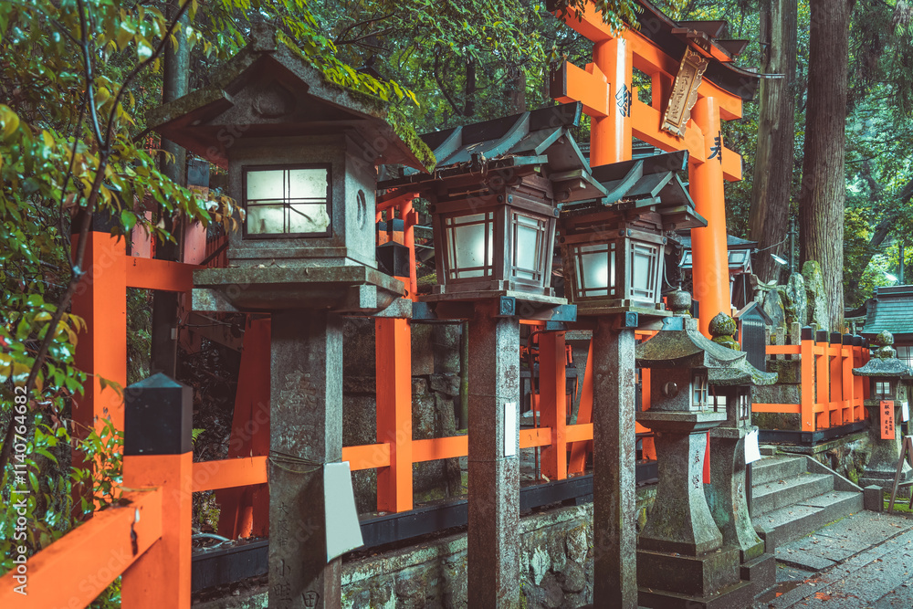 Traditional japanese stone toro lanterns at Fushimi Inari Taisha in Kyoto. (English translation of the japanese text: religious blessings)