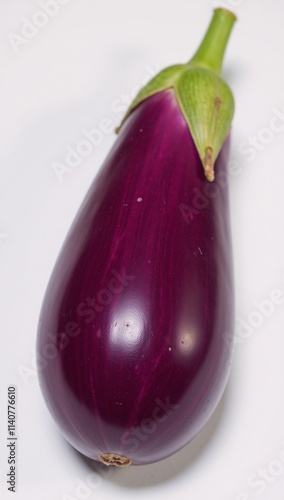 A glossy-surfaced vivid purple eggplant with fresh green stem for cooking or gardening photo