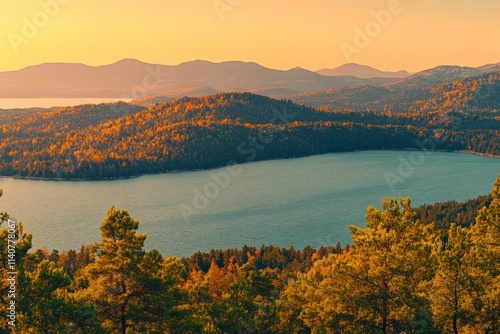 Serene landscape at sunset with mountains and a lake, showcasing nature's beauty.