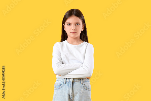 Upset teenage girl on yellow background