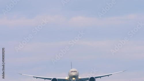 Cinematic footage of a modern airliner with its landing gear down flying low overhead