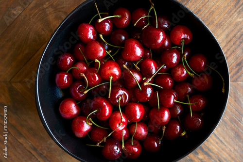 Cerezas frescas en un plato negro