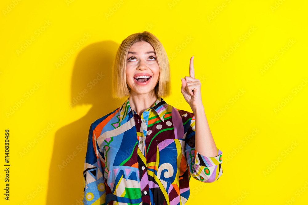 Photo portrait of lovely young lady look point empty space dressed stylish colorful garment isolated on yellow color background Photo portrait of lovely young lady look point empty space dressed stylish colorful garment isolated on yellow color background