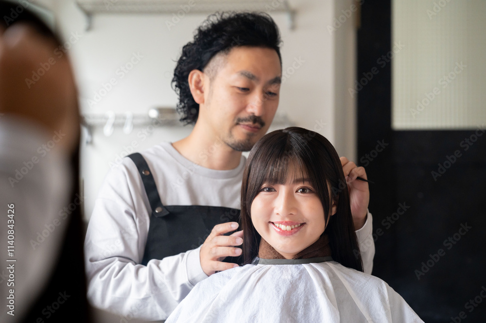 髪型の相談をする女性客と応対するスタッフ 髪型の相談をする女性客と応対するスタッフ