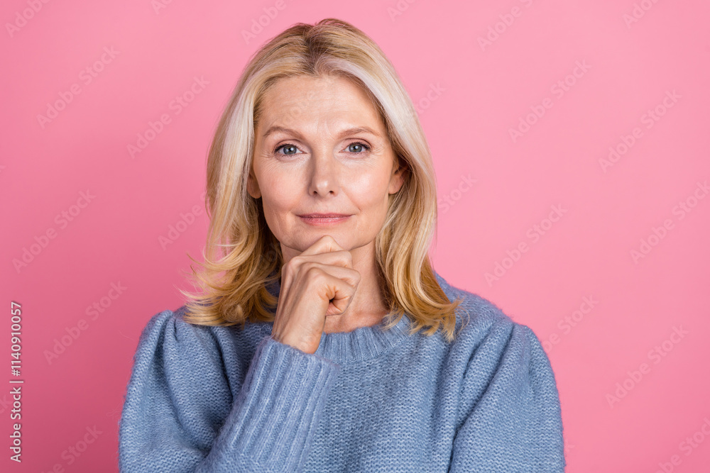 Photo portrait of attractive senior woman touch chin thinking dressed stylish blue knitted clothes isolated on pink color background Photo portrait of attractive senior woman touch chin thinking dressed stylish blue knitted clothes isolated on pink color background