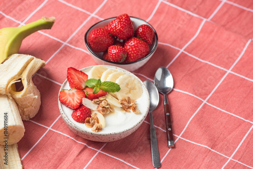 Schilderij op canvas Greek yogurt with fruits strawberry banana and crunchy granola in bowl