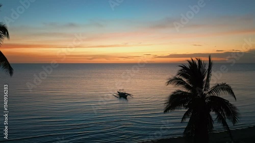 Sunset with a small Boat at the Beach with Palm Trees