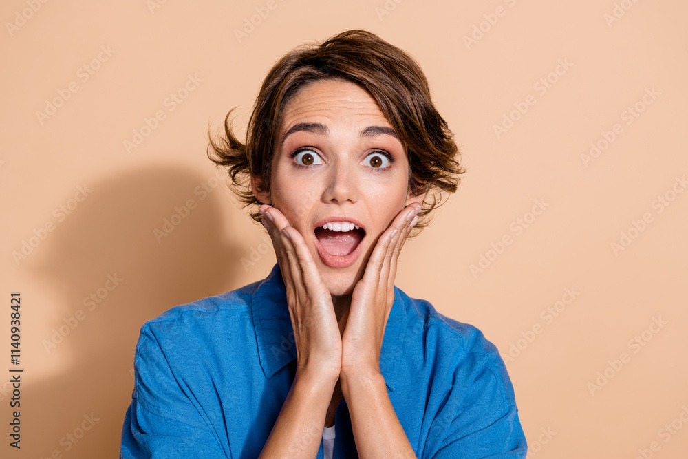 Photo portrait of lovely young lady touch cheeks impressed reaction wear trendy blue garment isolated on beige color background Photo portrait of lovely young lady touch cheeks impressed reaction wear trendy blue garment isolated on beige color background