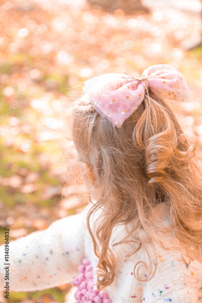 Naklejka premium little girl posing in an autumn environment with brown leaves