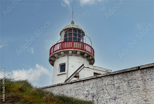 Looking uphill at an antique lighthouse no longer used photo