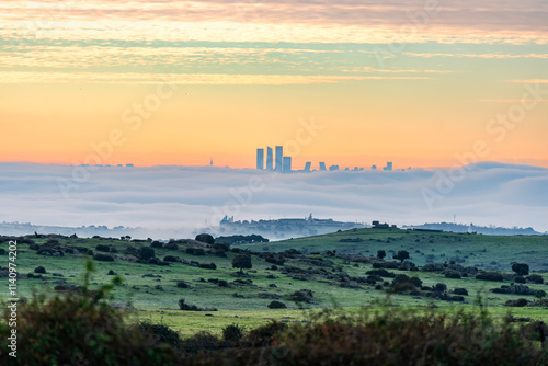 Golden sunset over the city of Madrid with the tall skyscrapers emerging above the fog.