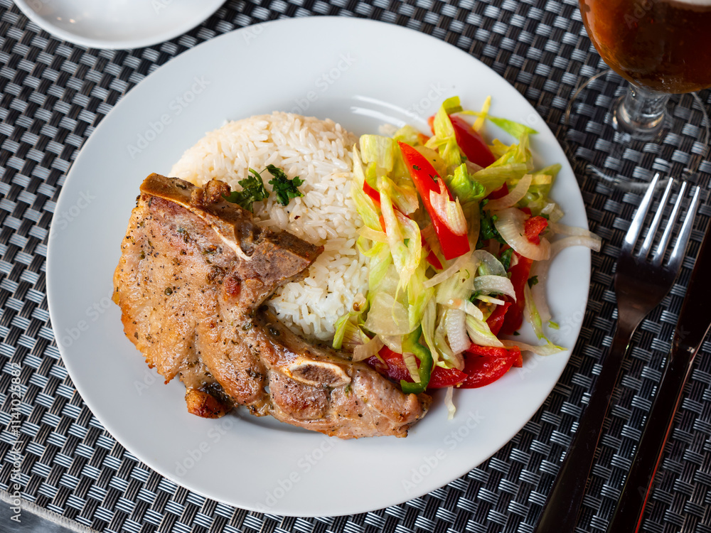 Pork chop with rice and vegetables. Latin American cuisine Pork chop with rice and vegetables. Latin American cuisine