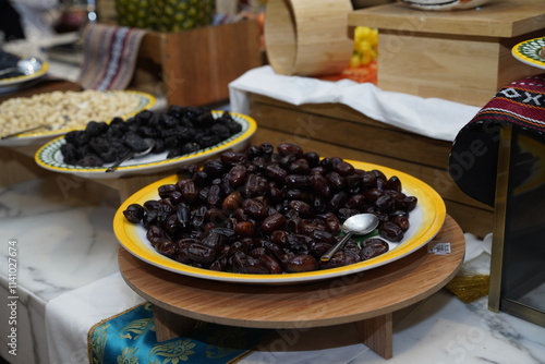 A lavish display of succulent dates elegantly arranged on a wooden platter, inviting guests to enjoy these rich, sweet treats at a vibrant buffet setting.