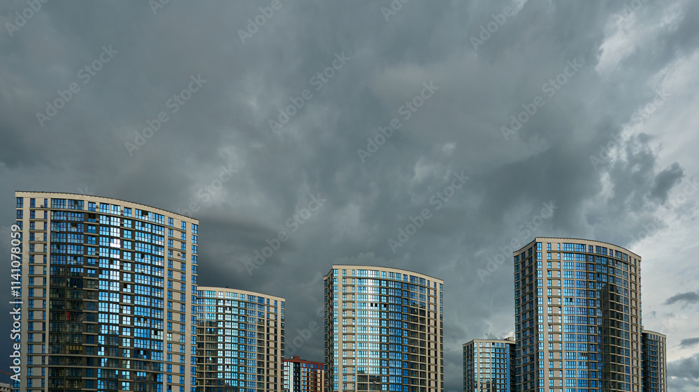Modern skyscrapers against the background of gray rain clouds. A new neighborhood in an Asian country. Modern skyscrapers against the background of gray rain clouds. A new neighborhood in an Asian country.