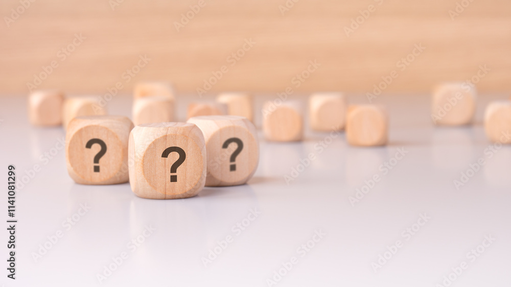 On the table sits a collection of mysterious wooden blocks adorned with question marks On the table sits a collection of mysterious wooden blocks adorned with question marks