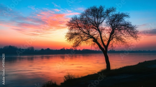 Serene Sunset Over Calm River with Silhouette of a Leafless Tree