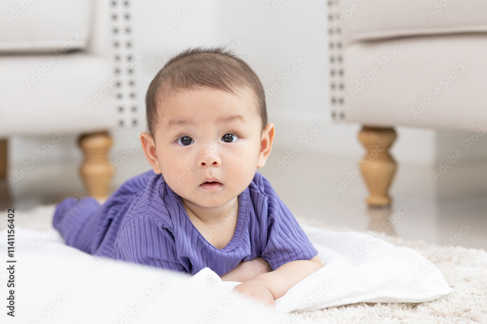 Asian newborn baby boy lying on the floor playing with colorful kid toys. Happy baby boy in kindergarten or daycare. Child playing with colorful educational toys in preschool. Asian boy. Asian newborn baby boy lying on the floor playing with colorful kid toys. Happy baby boy in kindergarten or daycare. Child playing with colorful educational toys in preschool. Asian boy.