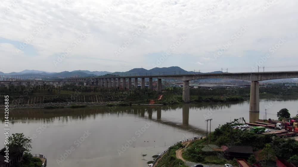 High speed rail bridge pier construction site aerial view in rural landscape with river and mountains High speed rail bridge pier construction site aerial view in rural landscape with river and mountains
