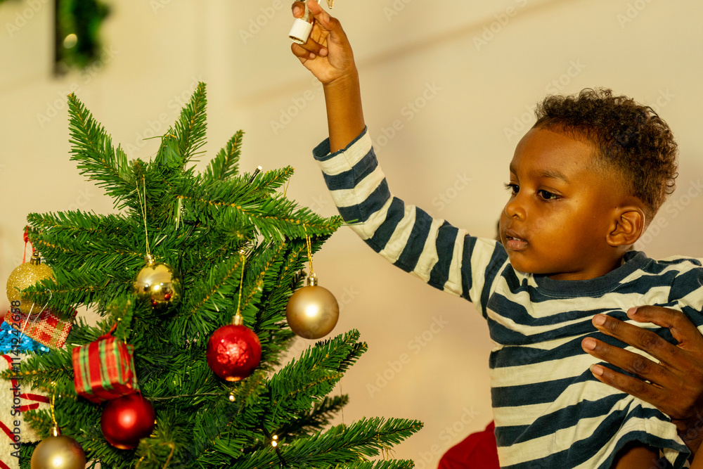 joyful moment as a father lifts his son to place the star on top of the Christmas tree, while another family member watches with admiration. The tree is beautifully decorated with colorful ornaments. joyful moment as a father lifts his son to place the star on top of the Christmas tree, while another family member watches with admiration. The tree is beautifully decorated with colorful ornaments.