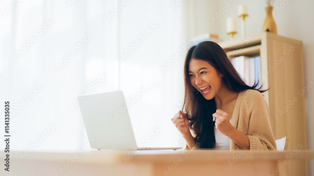 Funny euphoric young asian woman celebrating winning or getting ecommerce shopping offer on computer laptop. Excited happy girl winner looking at notebook celebrating success Funny euphoric young asian woman celebrating winning or getting ecommerce shopping offer on computer laptop. Excited happy girl winner looking at notebook celebrating success