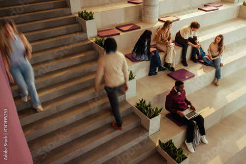 Photos University students studying and walking in modern building hall