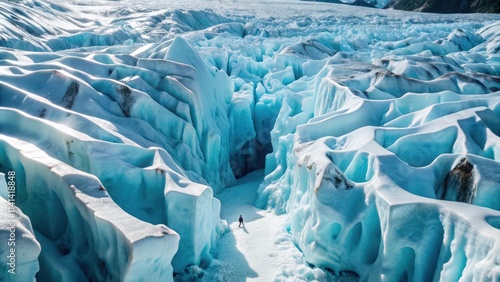 A lone figure walks across a vast expanse of glacier ice photo