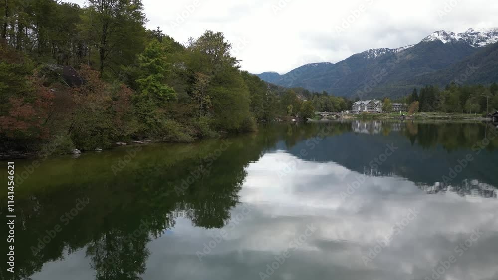 aerial drone shot flying over Bohinj lake with glassy reflection of mountains in in Triglav National Park in Slovenia aerial drone shot flying over Bohinj lake with glassy reflection of mountains in in Triglav National Park in Slovenia