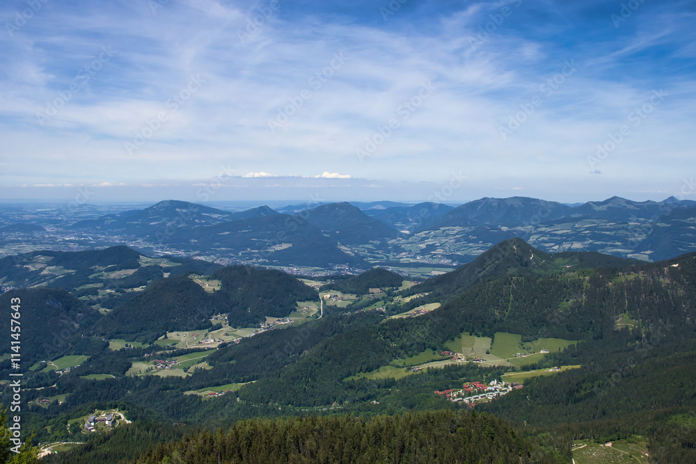 Fototapeta premium Looking down on hills and small villages below the Eagle's Nest on a spring day in Germany.