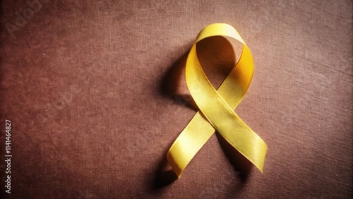 A Yellow Ribbon on a Brown Fabric Background