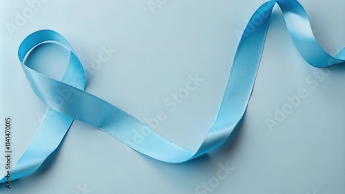 A Light Blue Satin Ribbon Curved on a Pastel Blue Background photo