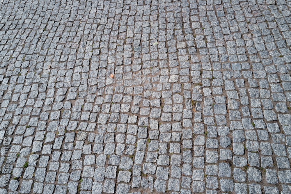 Stone road. Pavement texture. Stonework background for design. Granite cobblestoned pavement background. Abstract background of cobblestone pavement. Stone road. Pavement texture. Stonework background for design. Granite cobblestoned pavement background. Abstract background of cobblestone pavement.