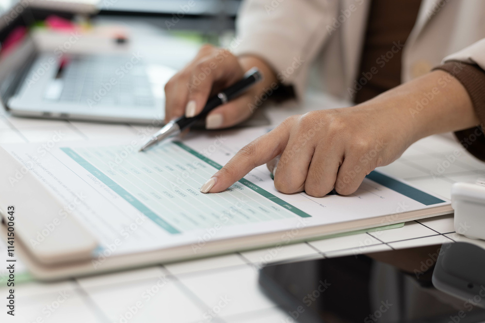 A woman is pointing at a graph on a piece of paper. The graph shows a comparison between two sets of data. The woman is using a pen to highlight the differences between the two sets of data A woman is pointing at a graph on a piece of paper. The graph shows a comparison between two sets of data. The woman is using a pen to highlight the differences between the two sets of data