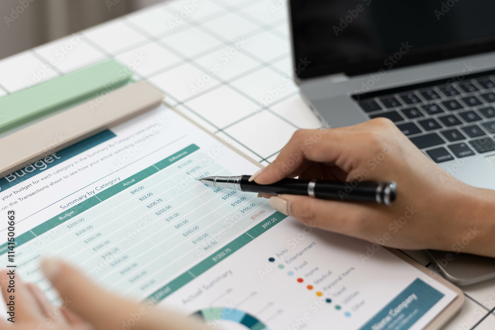 A woman is pointing at a graph on a piece of paper. The graph shows a comparison between two sets of data. The woman is using a pen to highlight the differences between the two sets of data A woman is pointing at a graph on a piece of paper. The graph shows a comparison between two sets of data. The woman is using a pen to highlight the differences between the two sets of data