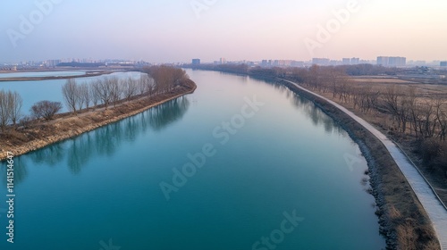 Wallpaper Mural A serene river view with trees along the banks and a pathway, reflecting calmness and nature. Torontodigital.ca