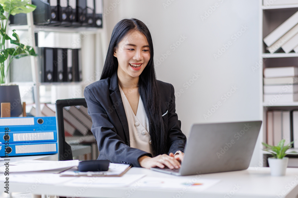 Happy busy young business woman entrepreneur in office using laptop at work, smiling professional asian female company executive manager working looking at computer at workplace. Happy busy young business woman entrepreneur in office using laptop at work, smiling professional asian female company executive manager working looking at computer at workplace.