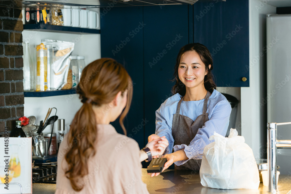 Obraz premium カフェ（飲食店）でスマートウォッチ決済をする女性