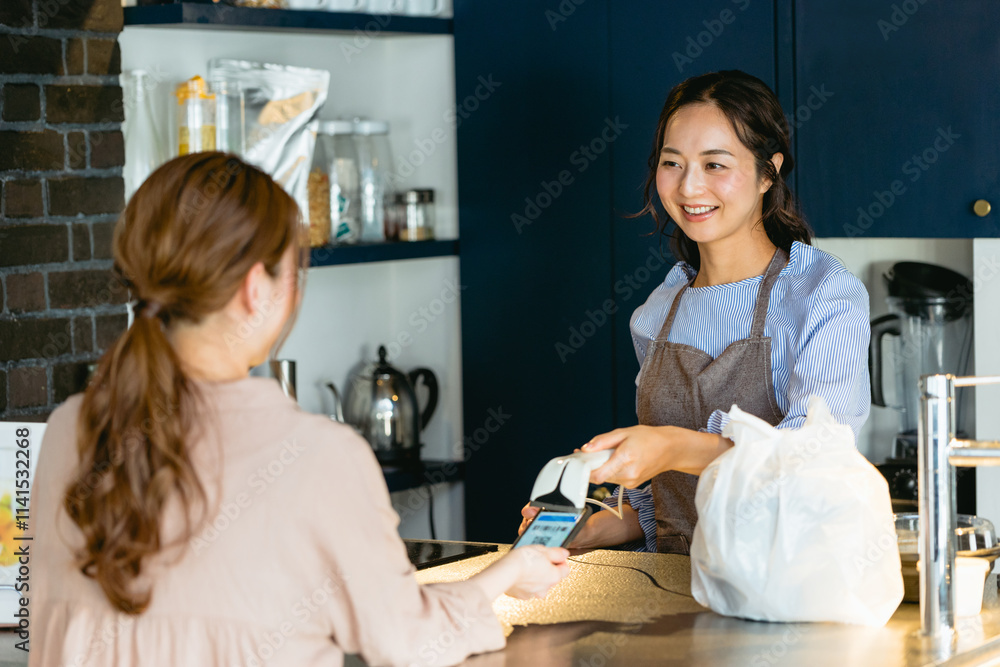 カフェ(飲食店)でバーコード決済をする女性 カフェ(飲食店)でバーコード決済をする女性