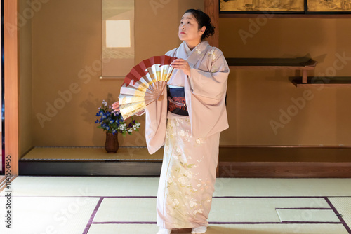 着物姿で扇子を持って日本舞踊を踊る年配の日本人女性 photo