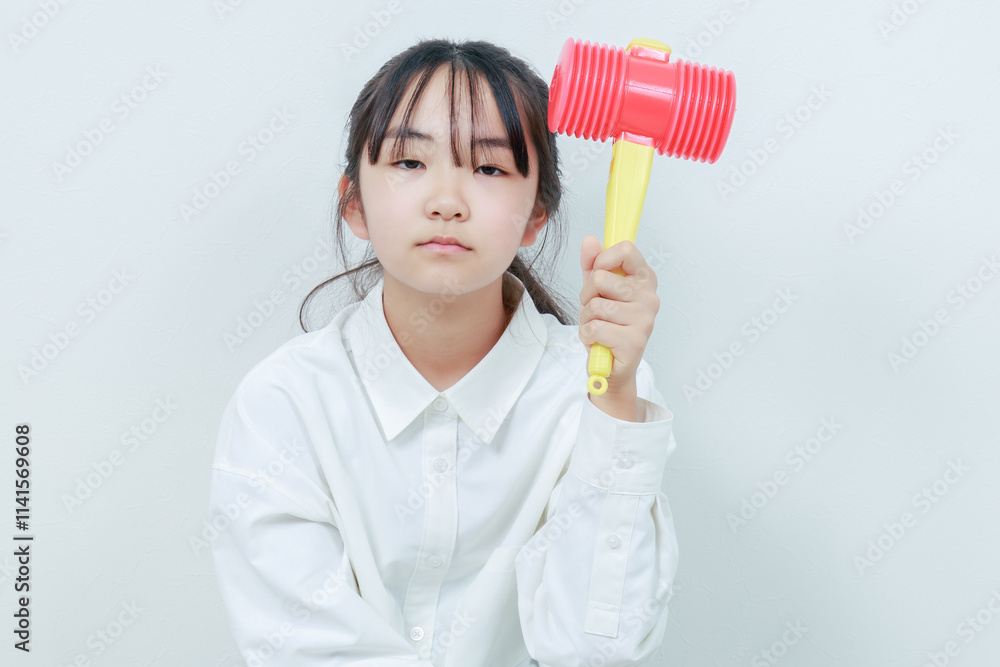 左手にハンマーを握る女の子のアップ