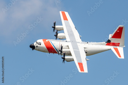 The U.S. Coast Guard C-130J aircraft soars through the sky, designed for search-and-rescue missions and coastal patrol operations.