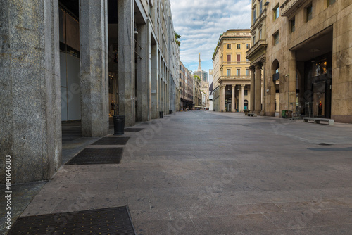 Milan city, Italy. Corso Vittorio Emanuele II in the historic center with the Milan Cathedral with the golden Madonnina in the background.  Very popular street full of shops