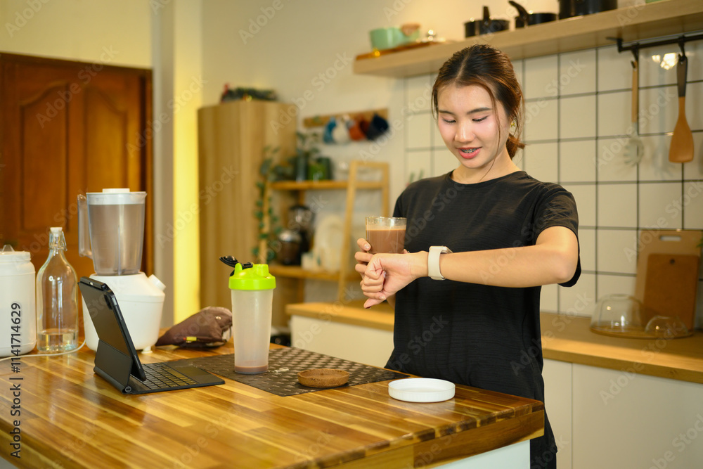 Beautiful asian woman drinking protein shake after workout and checking her smartwatch Beautiful asian woman drinking protein shake after workout and checking her smartwatch