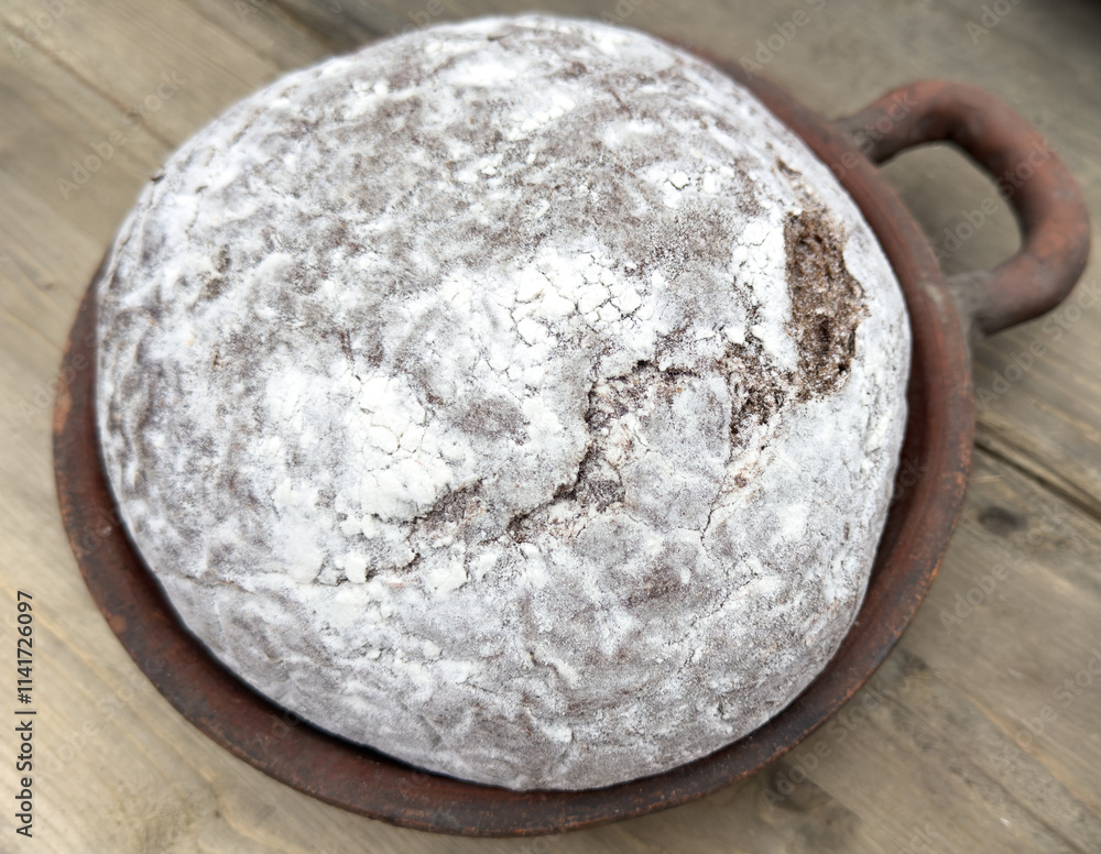 A piece of bread with a white crust sits in a brown bowl A piece of bread with a white crust sits in a brown bowl
