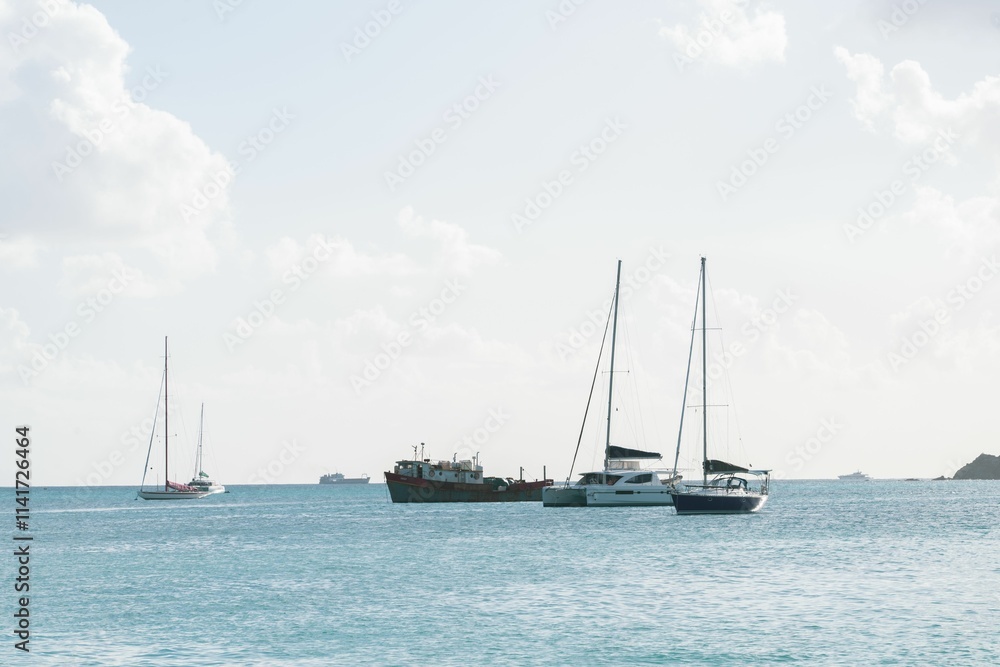 Sailboats on a tranquil sea under a bright sky. Sailboats on a tranquil sea under a bright sky.