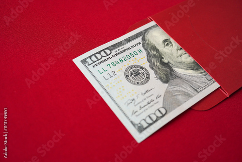 Lucky Asian chinese woman opening a red envelope gift, find large amount of money inside, one hundred united states dollars. Concept for Chinese New Year. photo