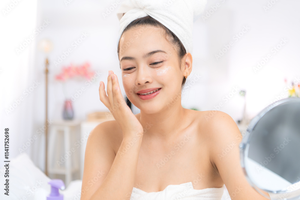 Asian young woman with towel wrapped on head and body applying makeup after shower, Morning beauty routine before work Asian young woman with towel wrapped on head and body applying makeup after shower, Morning beauty routine before work