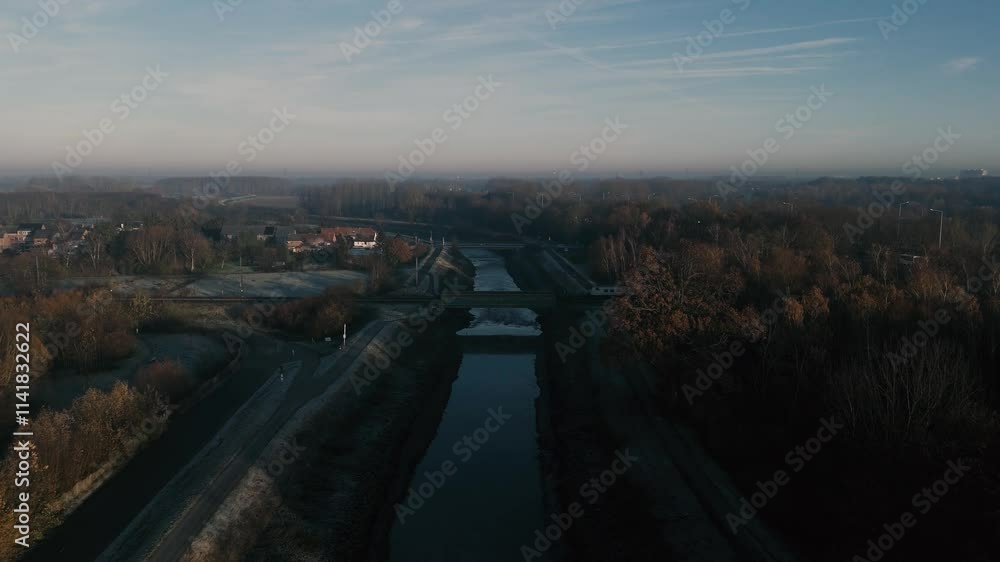 Drone shot of a train riding over a river near the suburbs during a sunny morning Drone shot of a train riding over a river near the suburbs during a sunny morning