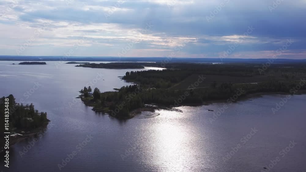 Aerial showing the swedish coastline during a sunny summer day, light rays shining through the clouds and the sunlight reflecting in the water Aerial showing the swedish coastline during a sunny summer day, light rays shining through the clouds and the sunlight reflecting in the water